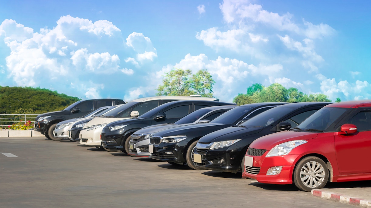 Cars parked in a row under a clear sky in Langkawi.