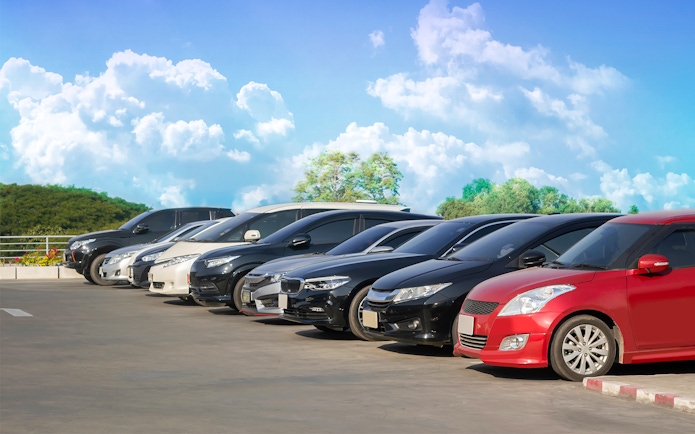 Cars parked in a row under a clear sky in Langkawi.