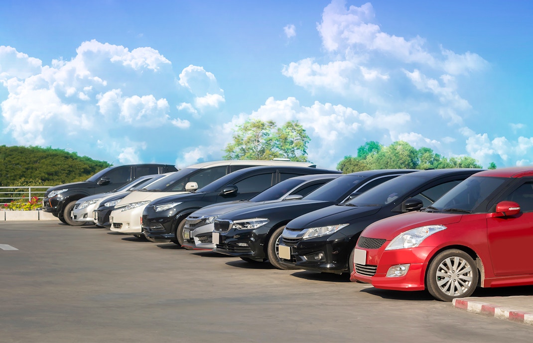 Cars parked in a row under a clear sky.