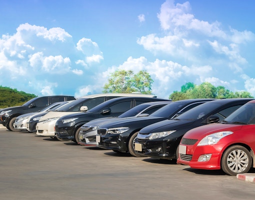 Cars parked in a row under a clear sky in Langkawi.