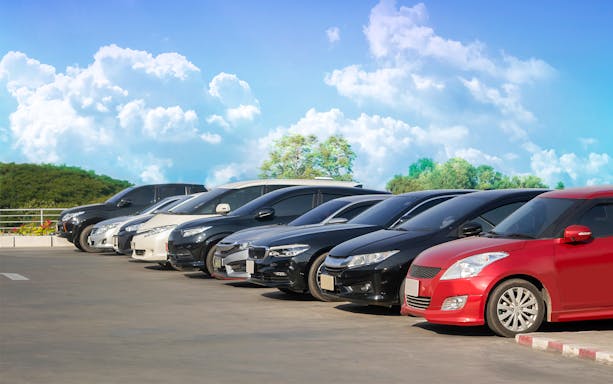 Cars parked in a row under a clear sky in Langkawi.