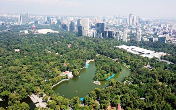 Aerial view of Chapultepec Park with lake and city skyline, Mexico City.