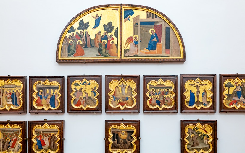 Accademia Gallery art display in Florence, Italy, featuring religious paintings with timed entry tickets.