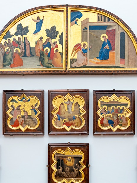 Accademia Gallery art display in Florence, Italy, featuring religious paintings with timed entry tickets.