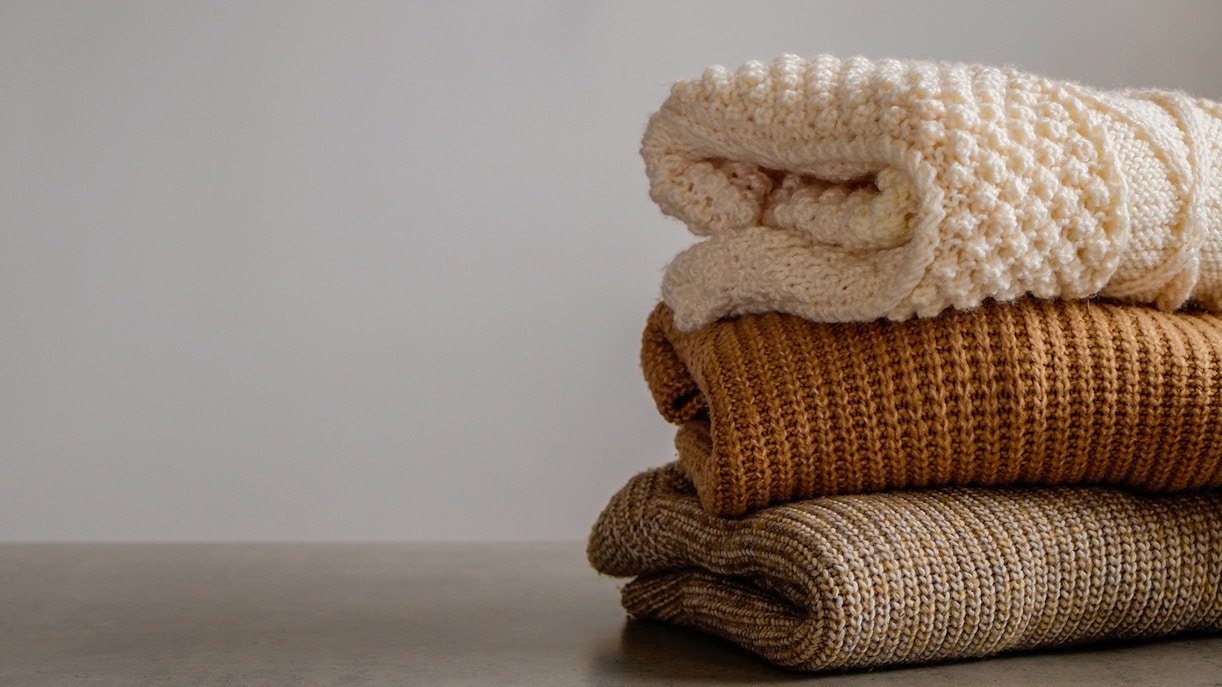 Stack of colorful knitted clothes in a cozy arrangement.