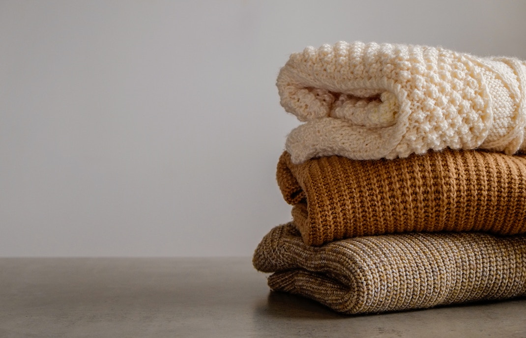 Stack of colorful knitted clothes in a cozy arrangement.