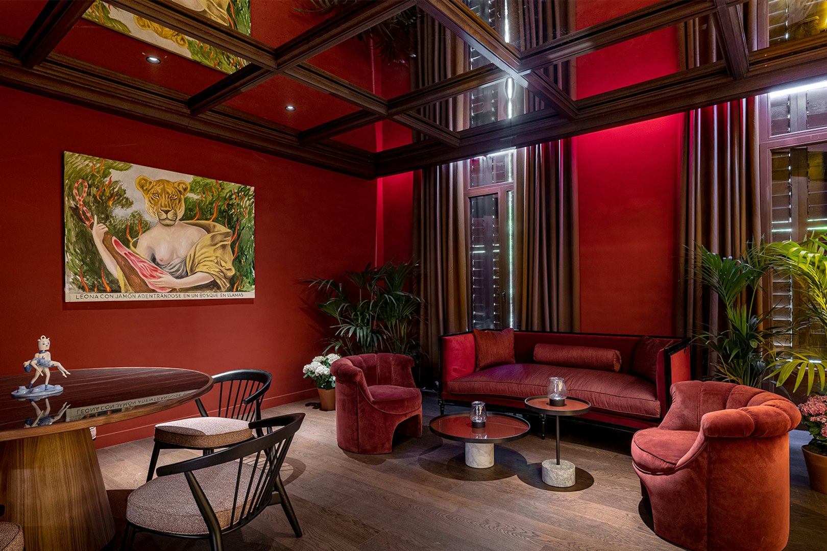 Elegant lounge with red decor and a painting of a lioness, setting for Flamenco De Leones Show.