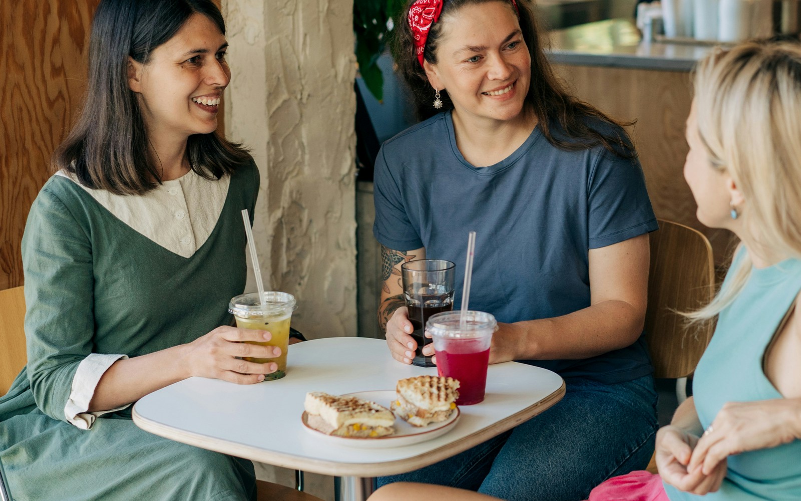 girls enjoying refreshing drinks and sandwichs at cafe