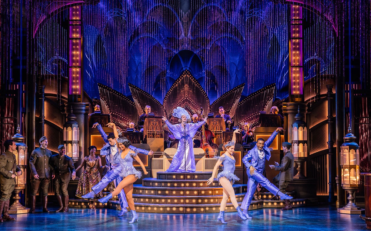 Stage performance of The Great Gatsby with dancers and musicians in vibrant costumes.