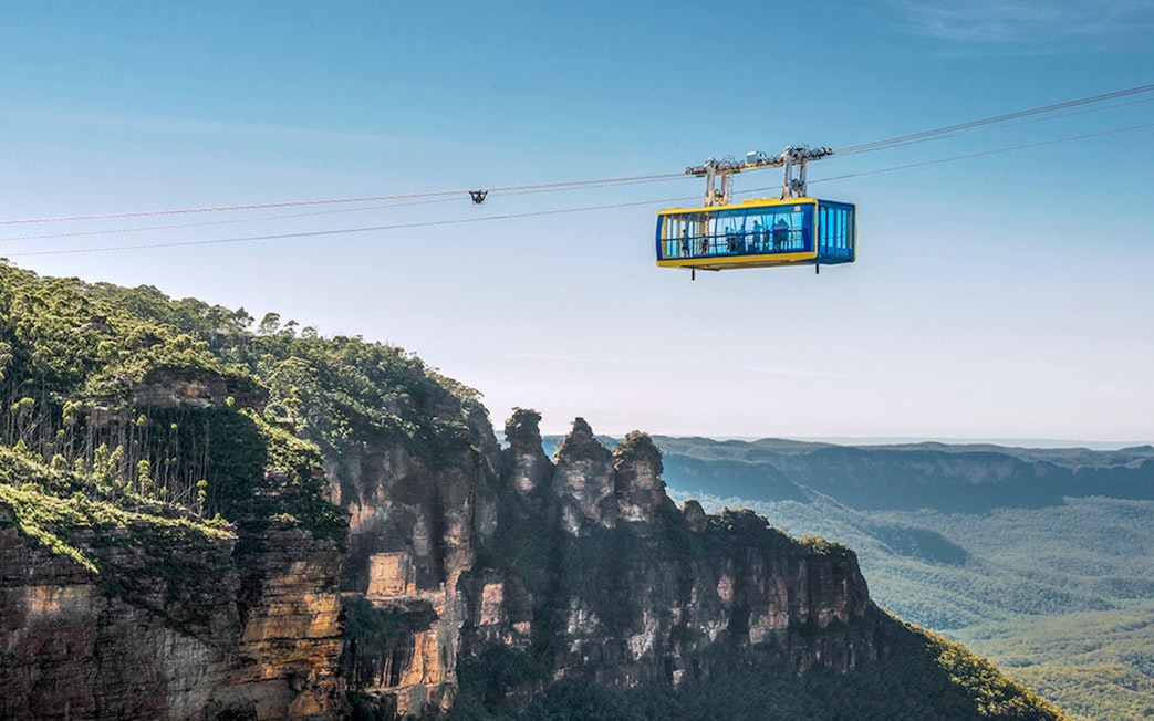 Scenic Skyway cable car over Blue Mountains, Australia, with forested cliffs below.
