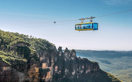 Scenic Skyway cable car over Blue Mountains, Australia, with forested cliffs below.