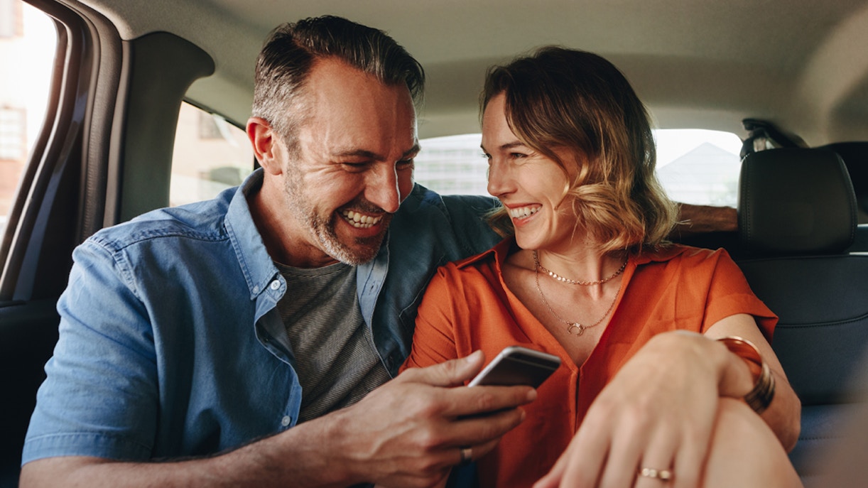 Couple smiling in back seat during Zone 1 Half Day Transfers.