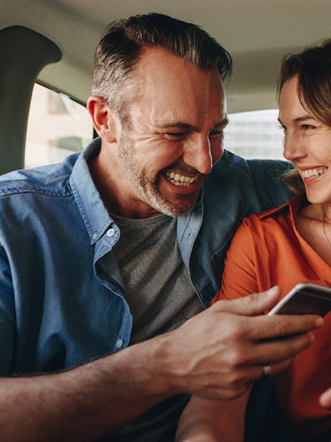 Couple smiling in back seat during Zone 1 Half Day Transfers.
