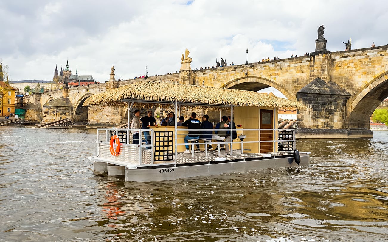 Tiki boat bar cruising near Charles Bridge in Prague.