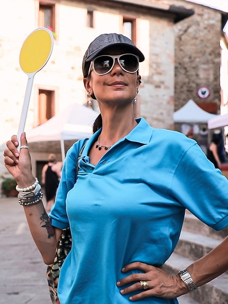 Tour guide holding a sign in a Chianti village during a wine tour from Florence.
