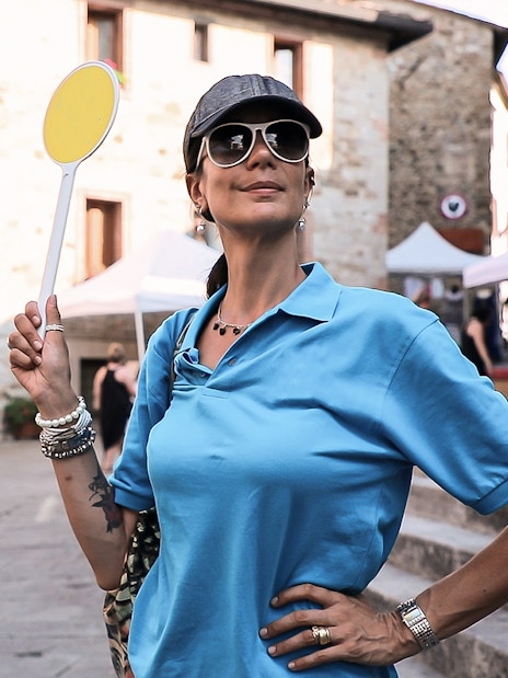 Tour guide holding a sign in a Chianti village during a wine tour from Florence.