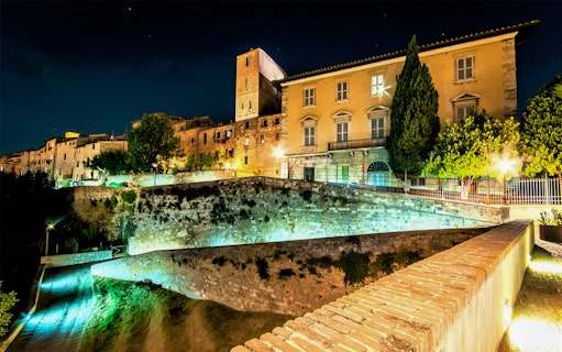 Night view of Museum of San Pietro in Colle Val d'Elsa with illuminated historic buildings.