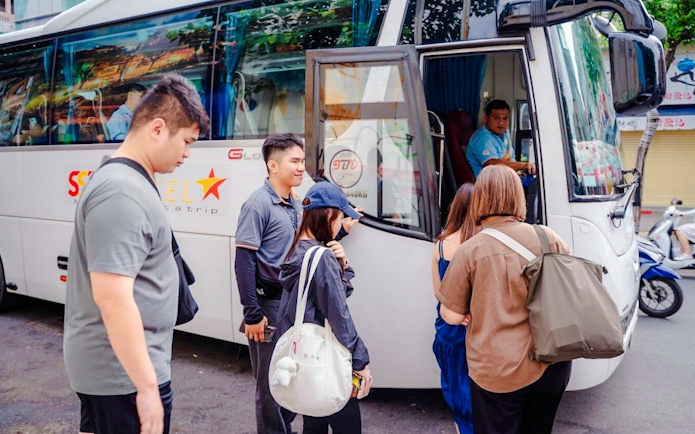 Tourists boarding a bus for transfers to Cu Chi tunnels.