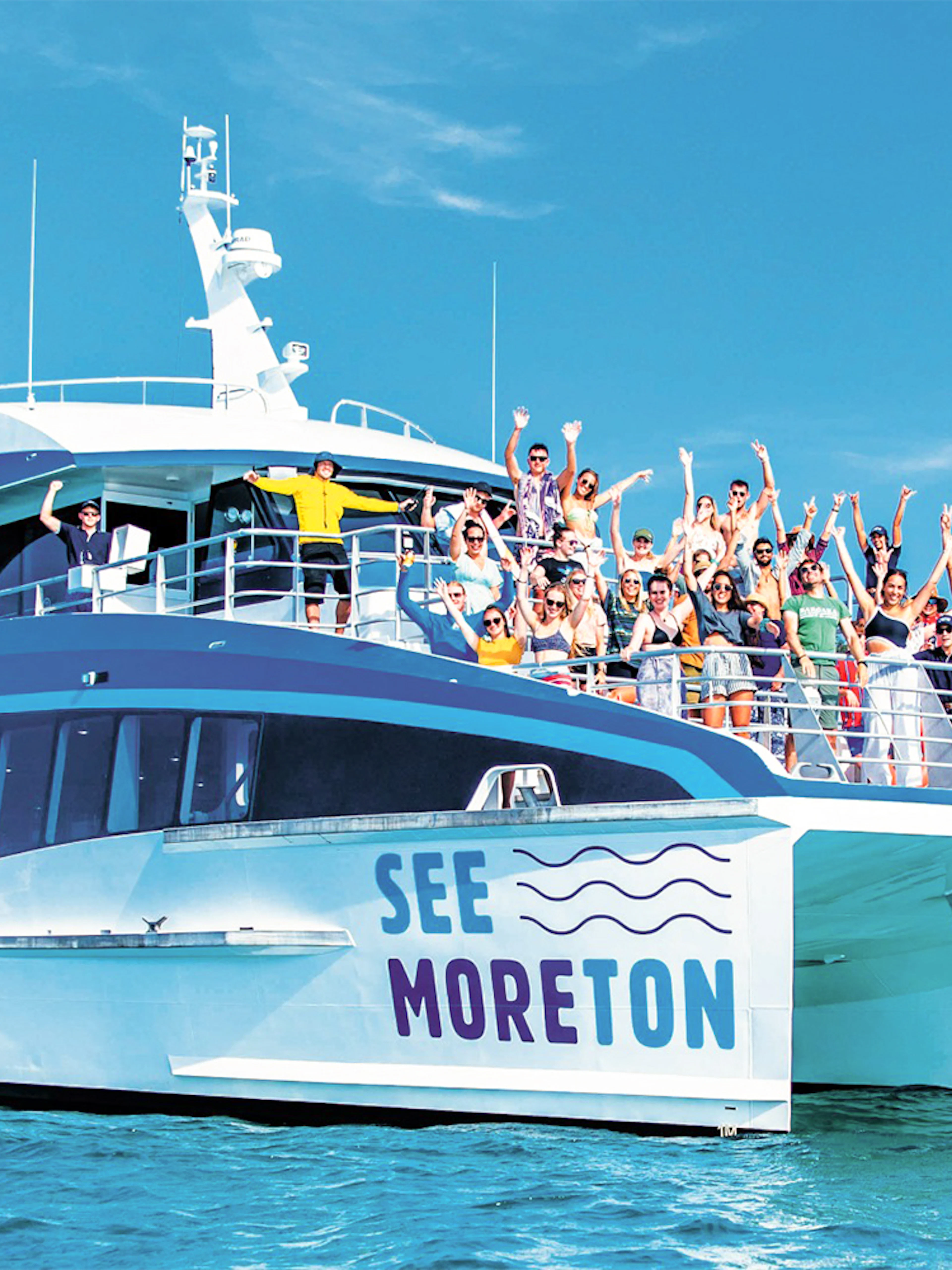 Tourists on a boat enjoying Moreton Island Marine Discovery Cruise.