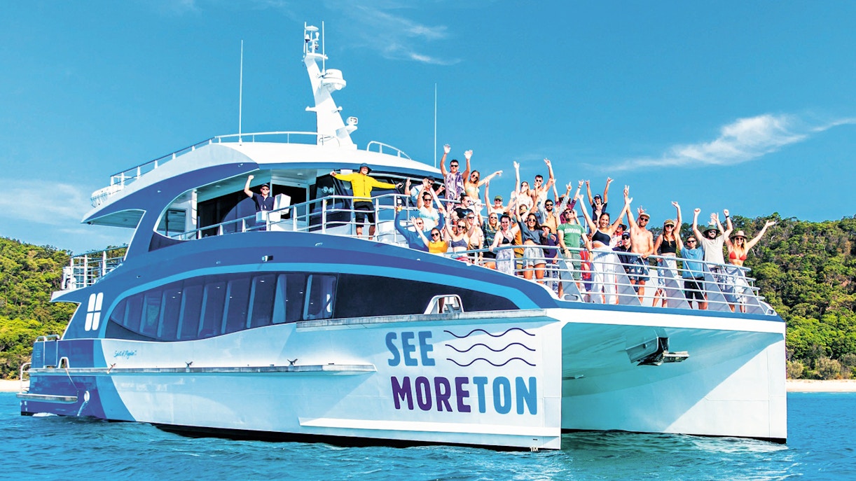 Tourists on a boat enjoying Moreton Island Marine Discovery Cruise.