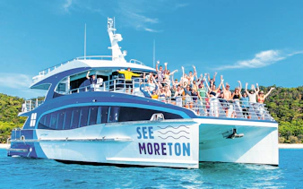Tourists on a boat enjoying Moreton Island Marine Discovery Cruise.