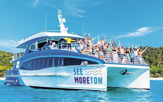 Tourists on a boat enjoying Moreton Island Marine Discovery Cruise.
