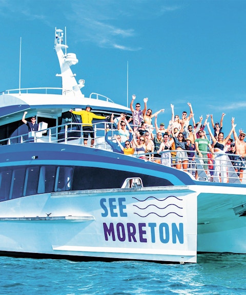 Tourists on a boat enjoying Moreton Island Marine Discovery Cruise.
