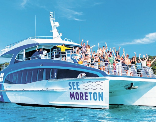 Tourists on a boat enjoying Moreton Island Marine Discovery Cruise.