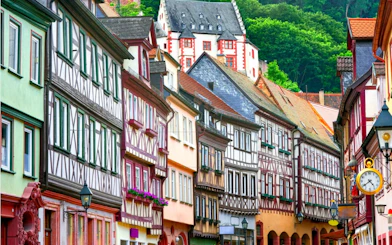 Half-timbered houses in Old Town Frankfurt, Germany, with colorful facades and a historic clock.
