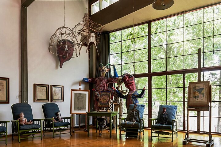 Diego Rivera's studio interior with large windows, art pieces, and sculptures in Museo Casa Estudio, Mexico City.