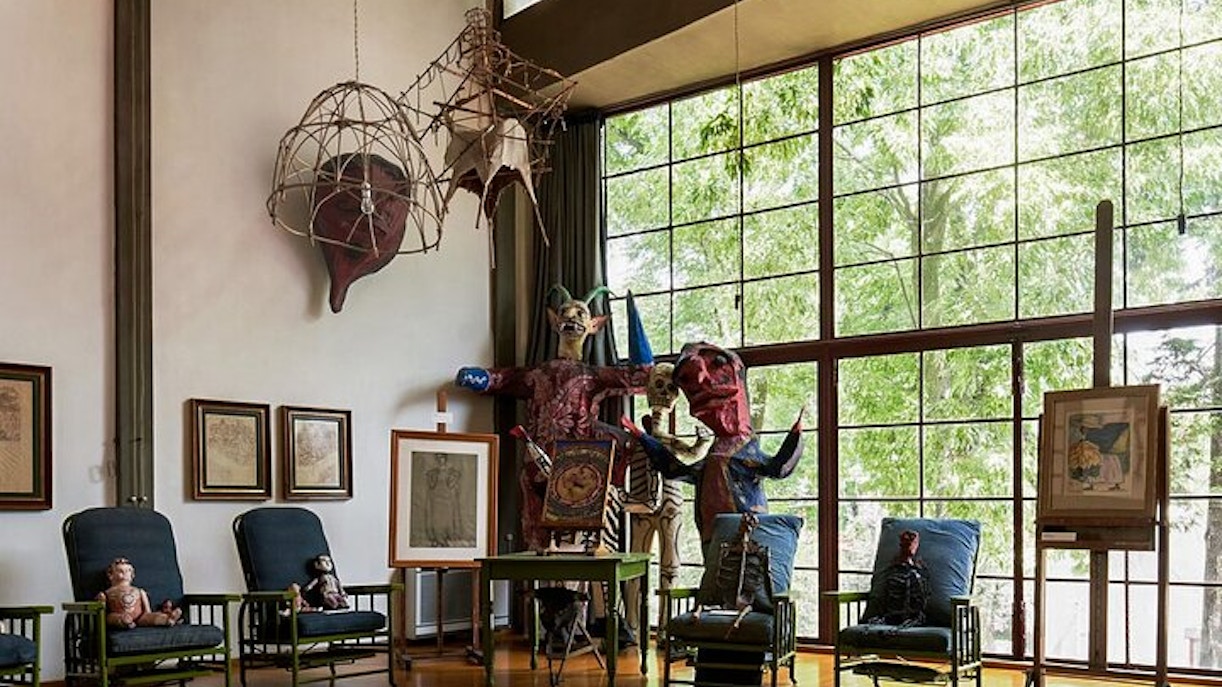Diego Rivera's studio interior with large windows, art pieces, and sculptures in Museo Casa Estudio, Mexico City.
