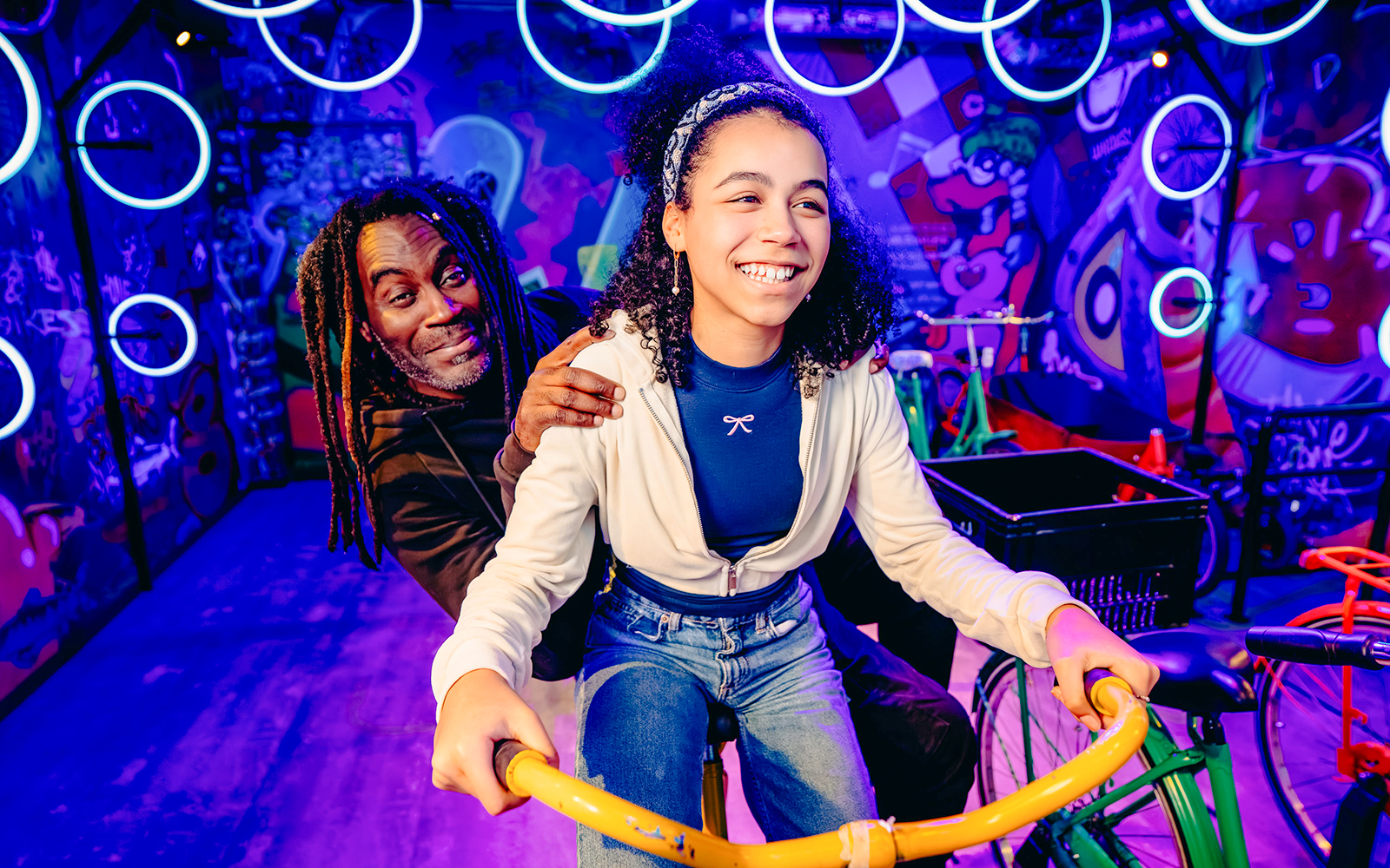 Guests enjoying a vibrant cycling experience in Holland with colorful graffiti backdrop.