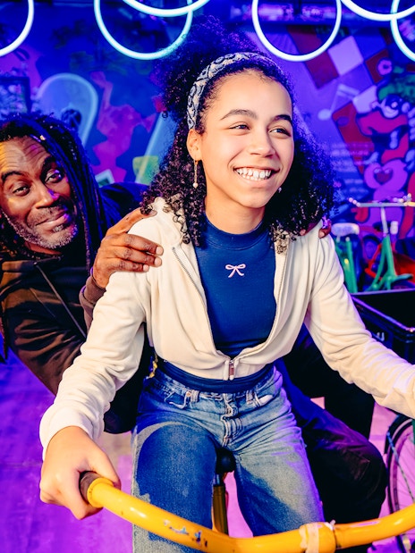 Guests enjoying a vibrant cycling experience in Holland with colorful graffiti backdrop.