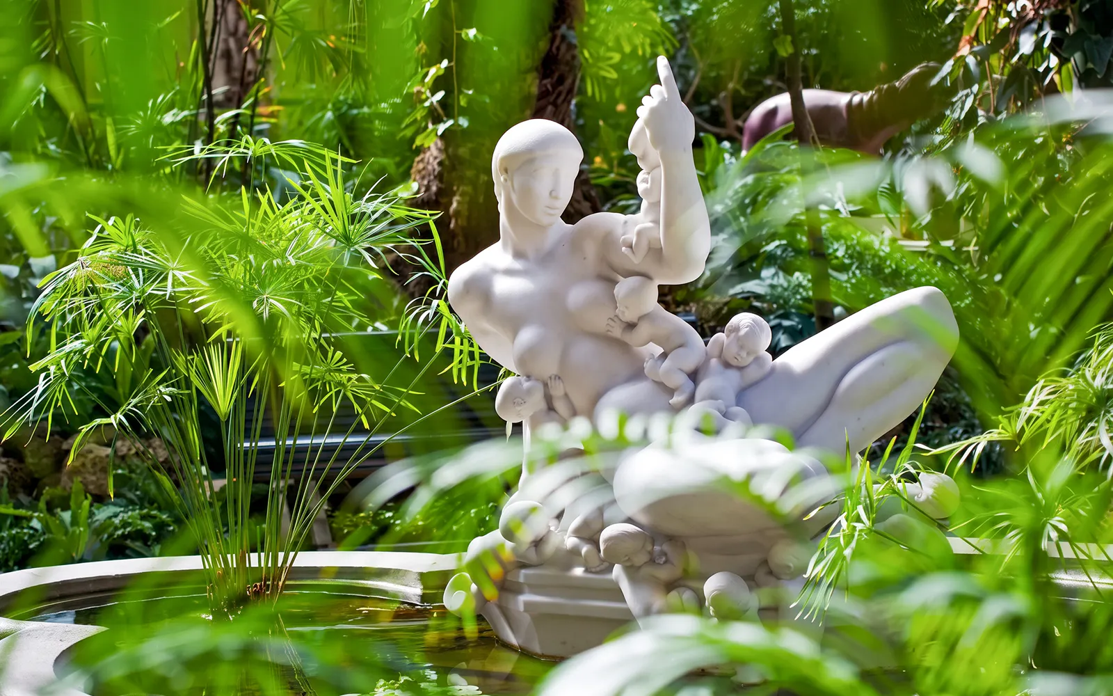 Marble sculpture "The Water Mother" surrounded by greenery at Ny Carlsberg Glyptotek, Copenhagen.