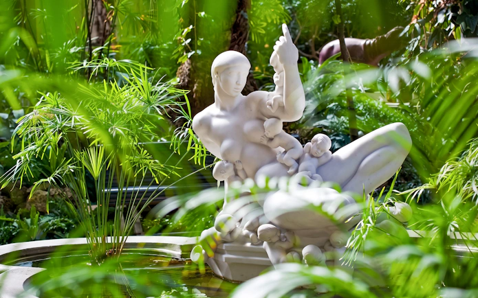 Marble sculpture "The Water Mother" surrounded by greenery at Ny Carlsberg Glyptotek, Copenhagen.