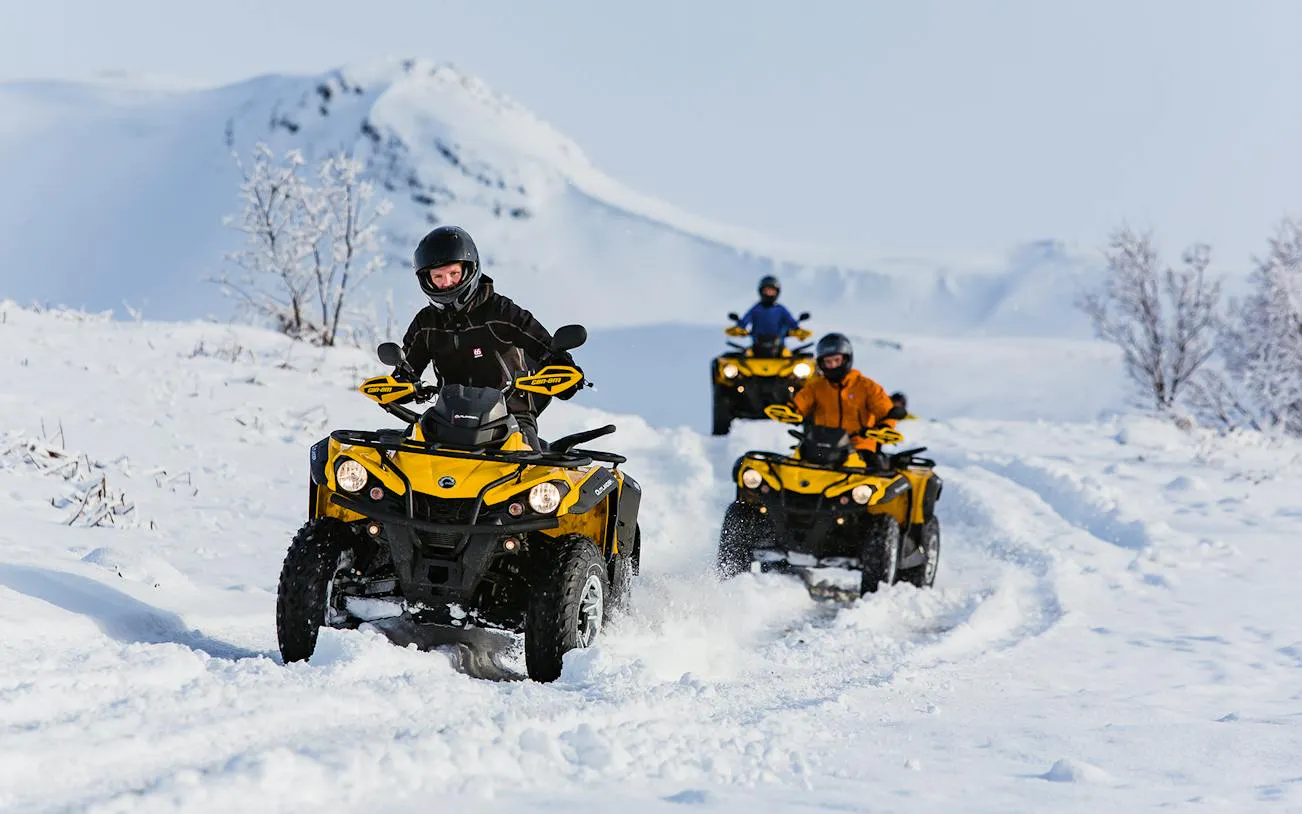 ATVs driving through snowy terrain with mountain backdrop on Twin Peaks tour, Reykjavik.