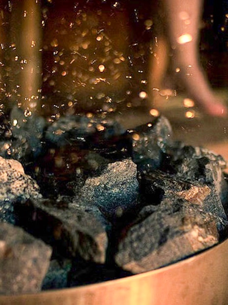 Burning coals and salts in a sauna during Northern Lights experience in Rovaniemi.