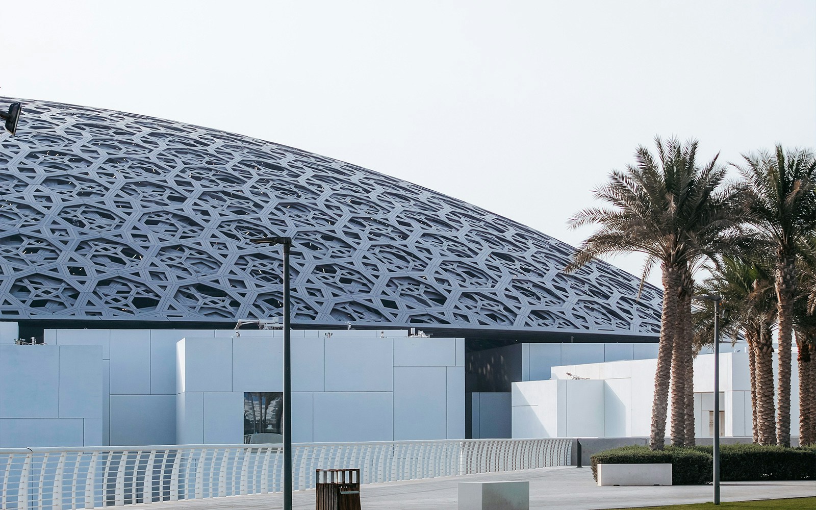 Louvre Abu Dhabi exterior with unique dome design reflecting sunlight.