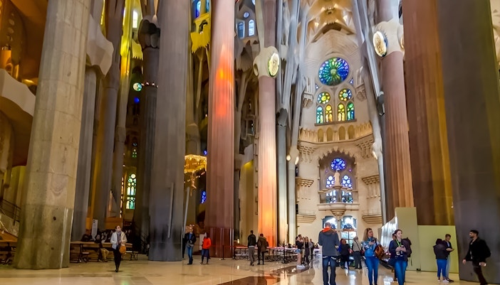 Sagrada Familia interior with intricate stained glass windows and towering columns in Barcelona, Spain.