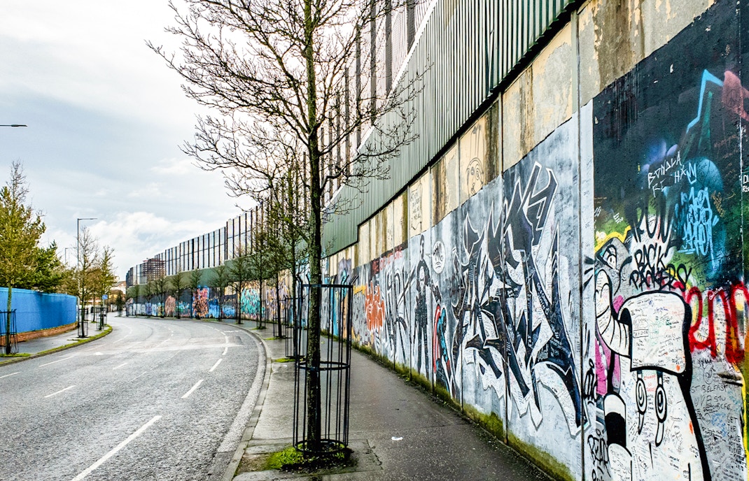 Belfast Peace Wall with colorful murals and messages of solidarity.