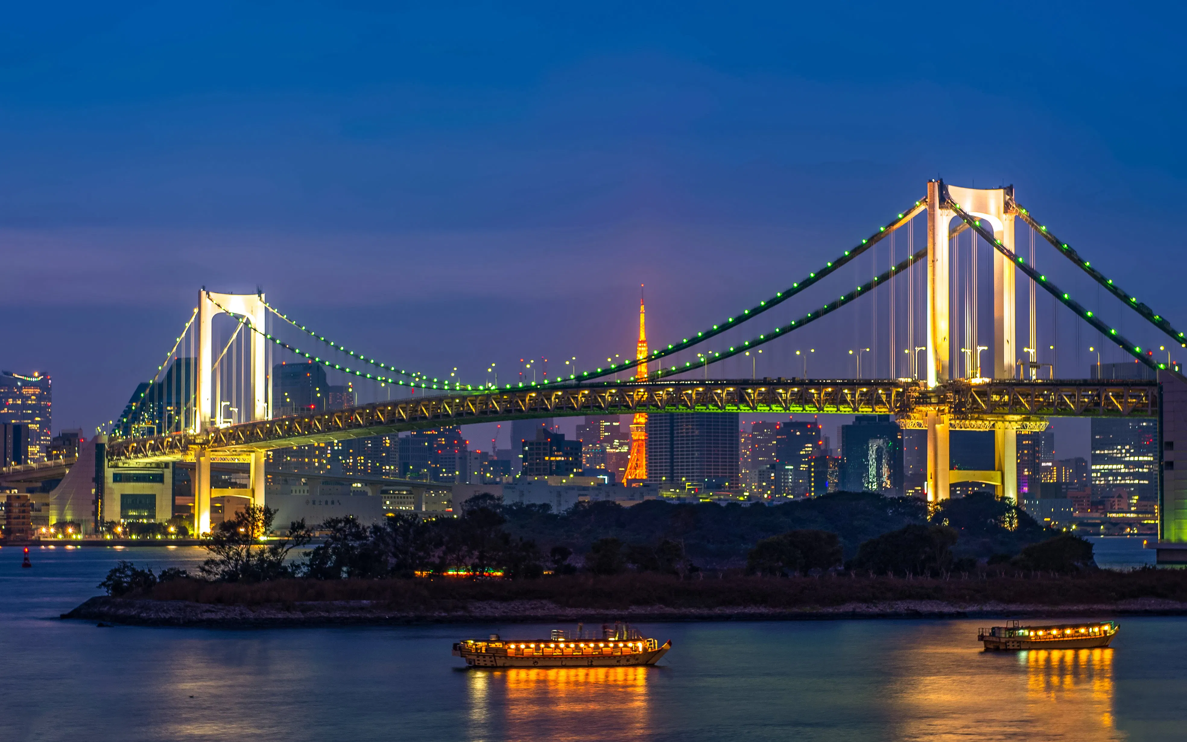 Tokyo Tower and Rainbow Bridge illuminated at sunset, Odaiba, Tokyo, Japan.