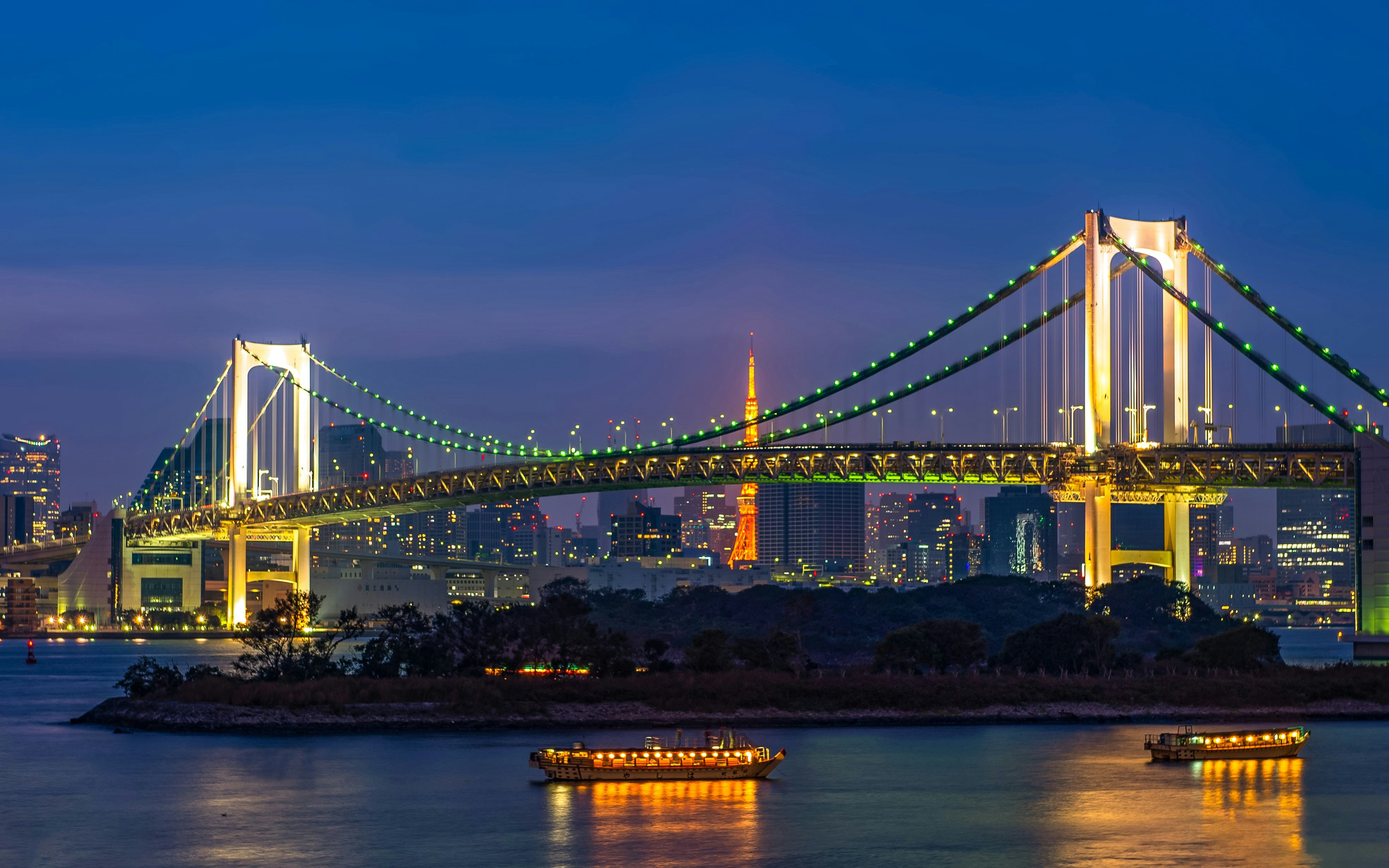 Tokyo Tower and Rainbow Bridge illuminated at sunset, Odaiba, Tokyo, Japan.