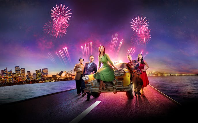 Guys & Dolls cast on a taxi with Sydney Harbour fireworks and skyline backdrop