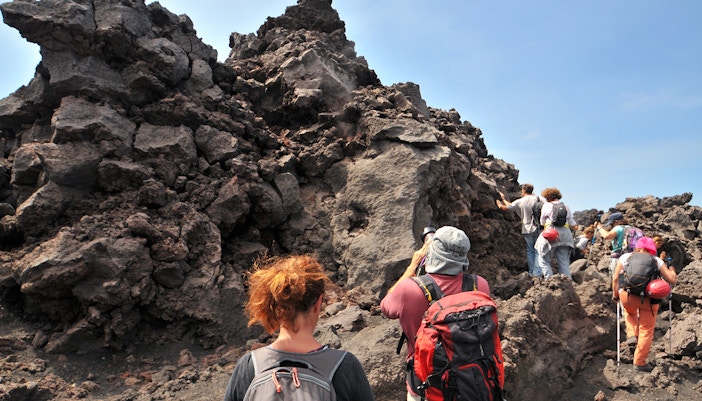 Mount Etna lava rock formations with guided tour group in Catania, Sicily.