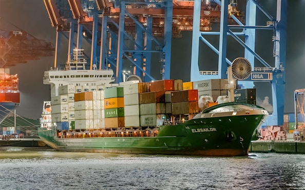 Cargo ship docked at night in Grand Harbor during evening lights cruise.