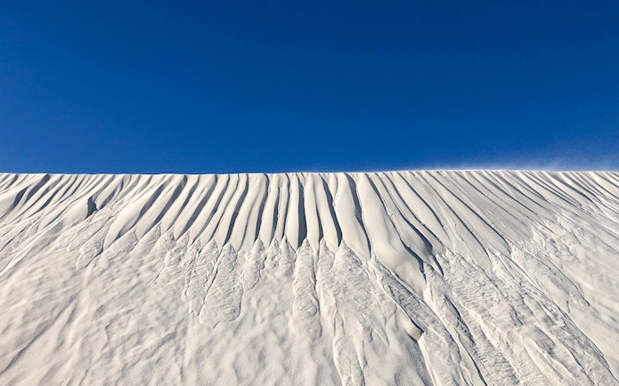 Sand dunes under a clear blue sky on Australia's Pinnacles tour.