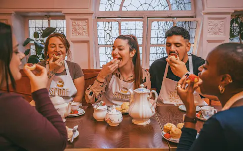 Participants enjoying scones and tea at a workshop in London.
