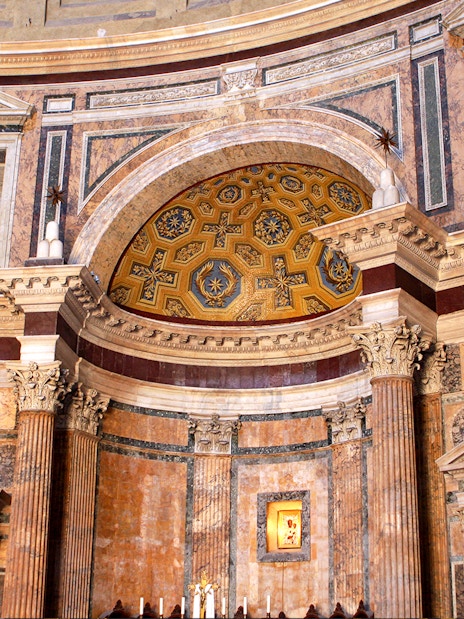 Interior view of the Roman Pantheon with ornate columns and detailed ceiling.