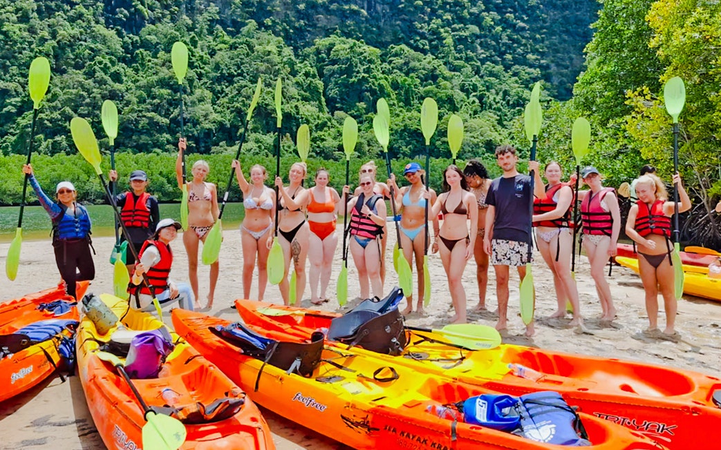 Tourists preparing to kayak at Ao Thalane, surrounded by mangrove forests.
