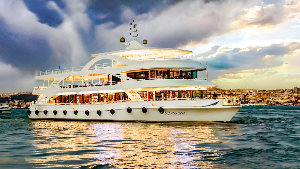 Bosphorus cruise ship sailing with cityscape in the background.